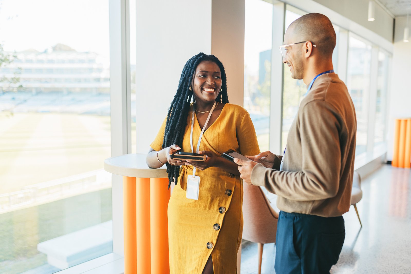 The Rise of Professional Services in Durham Region: Why Businesses Are Choosing to Grow Here happy business partners talking beside window in coworking office space